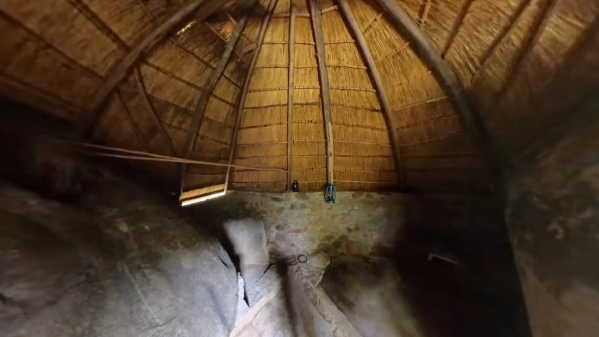 Inside a thatched hut built against the granite rock face