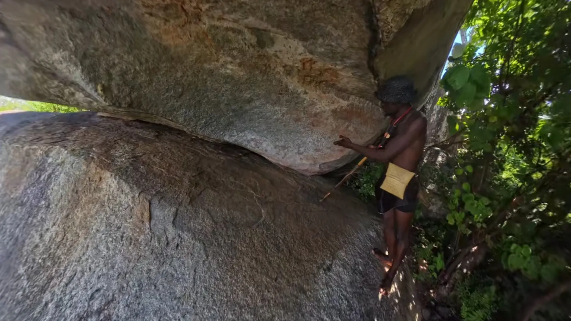 Trymore pointing out rock art on a granite overhang